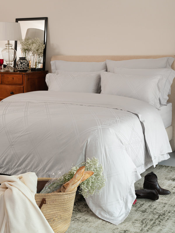 A bedroom featuring Marialma's Grey Sensitive Zinc Duvet Cover with jacquard design