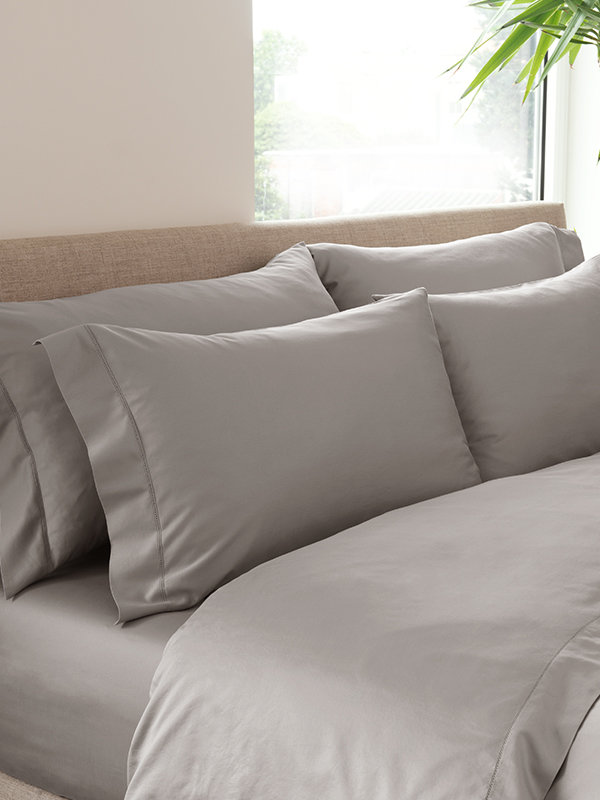 Marialma's Ice Grey Sensitive Zinc Pillowcase Set on top of a bed with Marialma's ice grey bed sheets