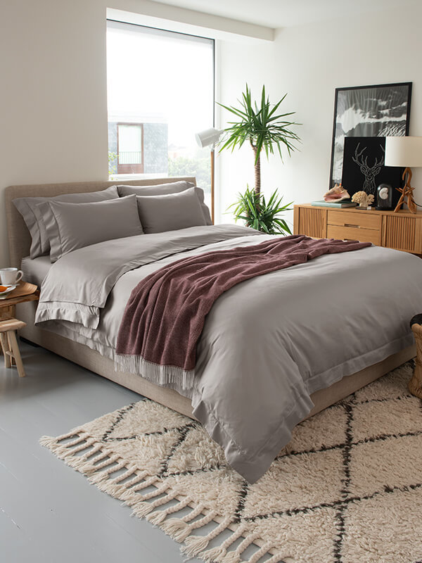 A bedroom design that features Marialma's Grey performance bedding and alpaca throw