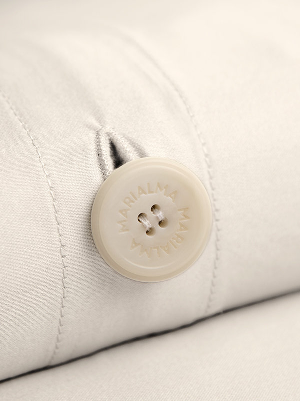 Detail of a Marialma's biodegradable button from an Ivory Cosmetic Algae Duvet Cover