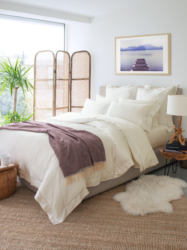 A bedroom design that features Marialma's Ivory Cosmetic Algae Fitted Sheet and alpaca throw