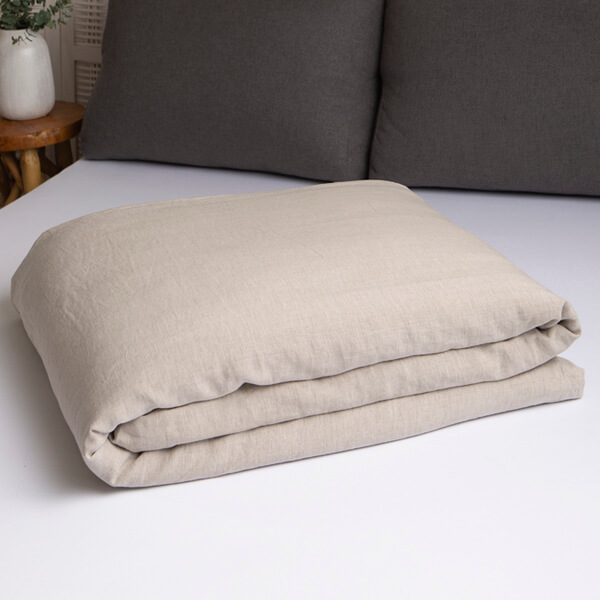 Marialma's natural hemp duvet cover folded on top of a bed