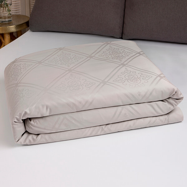 Marialma's Sensitive Zinc Duvet Covet Set with Jacquard Faro folded on top of a bed
